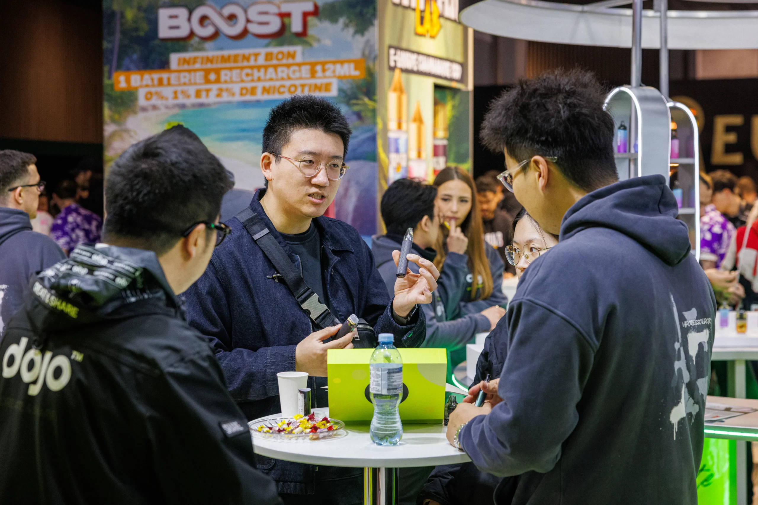 Présentation et démonstration d'une cigarette électronique sur un stand d'exposition au Vapexpo Paris.