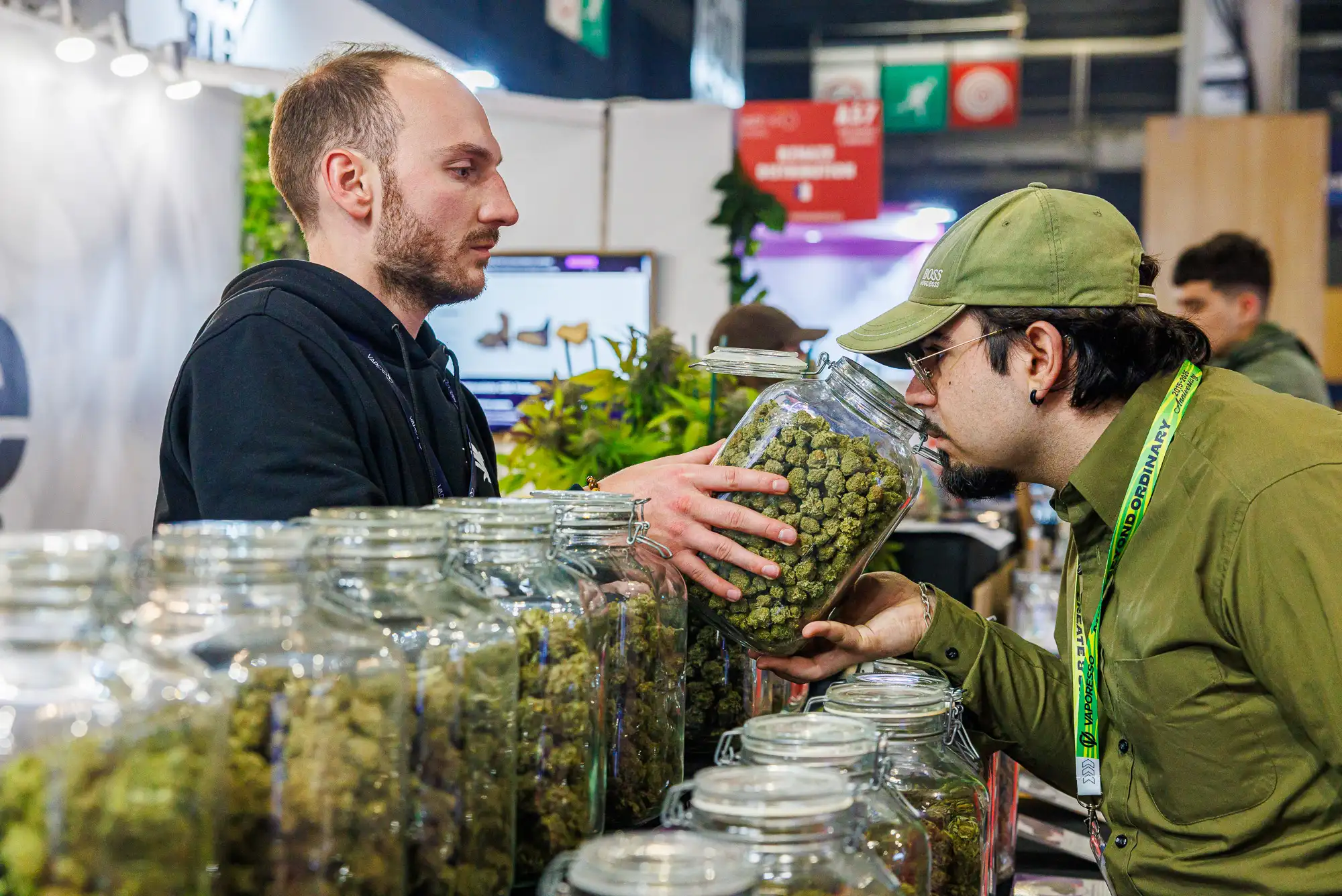 Un visiteur sent un bocal de fleurs de CBD sur un stand d'exposition au salon Vapexpo Paris