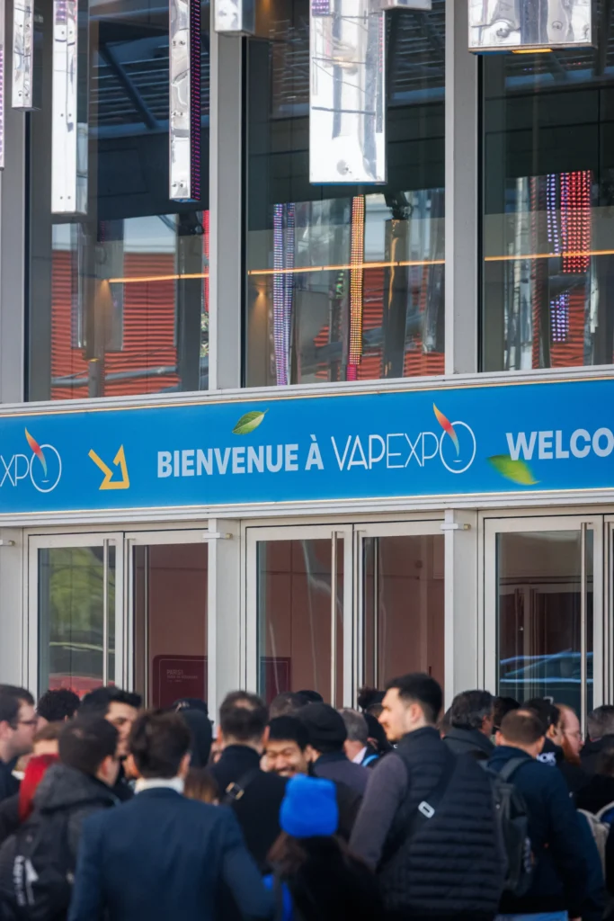 File d'attente des visiteurs devant l'enseigne Bienvenue à Vapexpo à l'entrée du salon